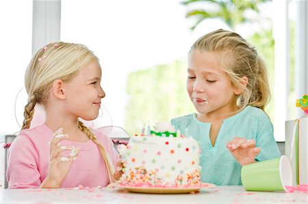 Two girls eating birthday cake Stock Photo - Premium Royalty-Free, Code: 6108-05874088