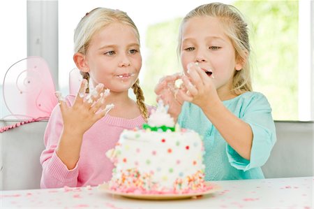 simsearch:6108-05865577,k - Two girls eating birthday cake Stock Photo - Premium Royalty-Free, Code: 6108-05874089