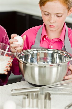 simsearch:6108-05869331,k - Two girls cooking food in the kitchen Stock Photo - Premium Royalty-Free, Code: 6108-05874097