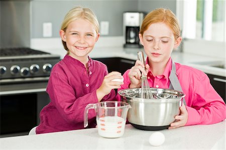 simsearch:6108-05869331,k - Two girls cooking food in the kitchen Stock Photo - Premium Royalty-Free, Code: 6108-05874096