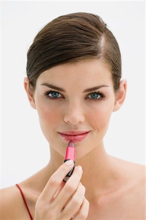simsearch:6108-05863589,k - Fashion model applying lipstick on her lips Foto de stock - Sin royalties Premium, Código: 6108-05874279