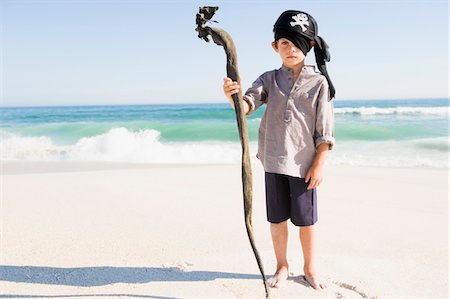 pirate - Boy in pirate costume standing on the beach Stock Photo - Premium Royalty-Free, Code: 6108-05874380