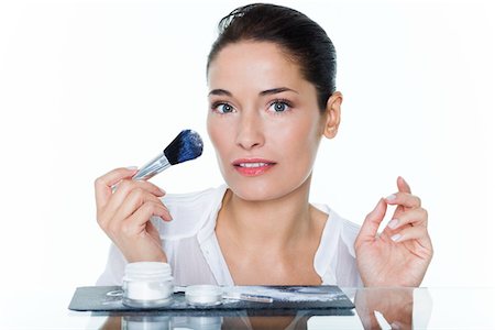 simsearch:6108-05869249,k - Young woman holding make-up brush Stock Photo - Premium Royalty-Free, Code: 6108-05874873