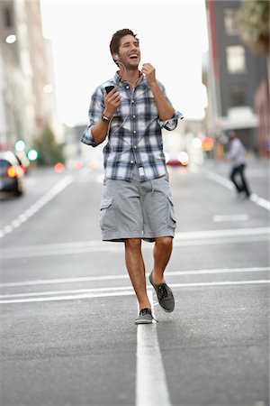 Man talking on a mobile phone while walking on the road Foto de stock - Sin royalties Premium, Código: 6108-05874991