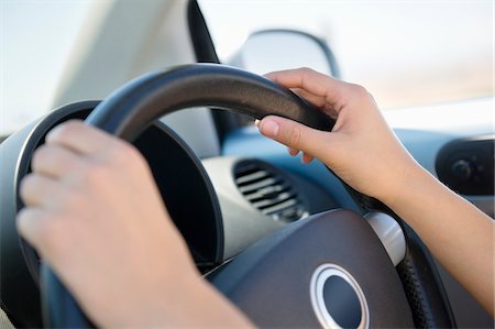 Close-up of a young woman's hand holding steering wheel Stock Photo - Premium Royalty-Free, Code: 6108-05874925
