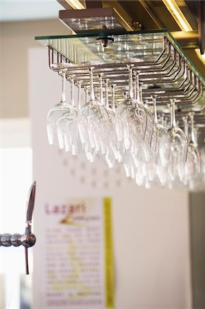 Wine glasses hanging upside down in a bar Stock Photo - Premium Royalty-Free, Code: 6108-05875049