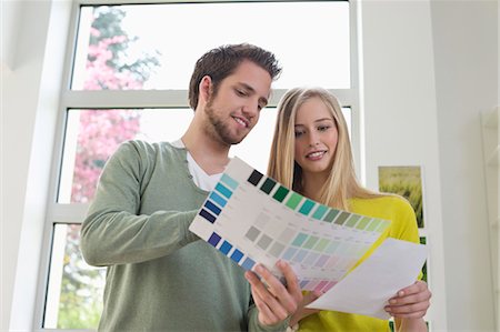 Couple choosing color for their house from a color chart Stock Photo - Premium Royalty-Free, Code: 6108-06166505