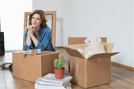 pile of books - Woman leaning on cardboard box and thinking Stock Photo - Premium Royalty-Free, Code: 6108-06166506