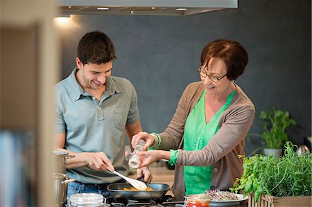 Woman assisting her son to cook food Stock Photo - Premium Royalty-Free, Code: 6108-06166657