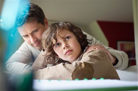 studying - Boy thinking while studying with his father at home Stock Photo - Premium Royalty-Free, Code: 6108-06166607