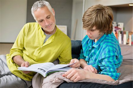 Teenage boy studying with his father at home Stock Photo - Premium Royalty-Free, Code: 6108-06166618