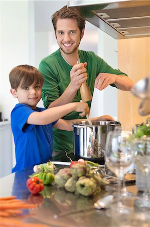 Boy assisting his father in the kitchen Stock Photo - Premium Royalty-Free, Code: 6108-06166742