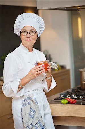 Woman holding a jar of tomato sauce Stock Photo - Premium Royalty-Free, Code: 6108-06166763