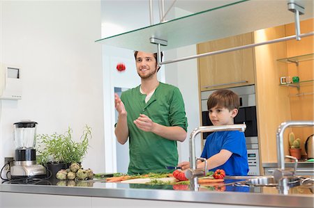 Man and son cutting vegetables in the kitchen Stock Photo - Premium Royalty-Free, Code: 6108-06166764