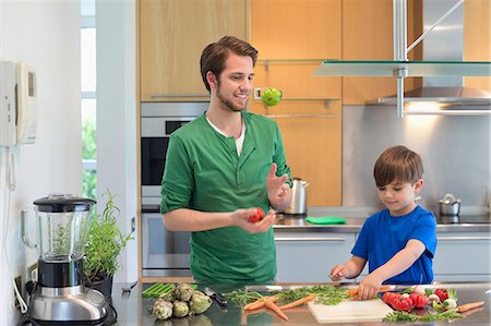Man and son cutting vegetables in the kitchen Stock Photo - Premium Royalty-Free, Code: 6108-06166786