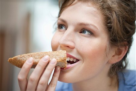 Close-up of a woman eating toast Stock Photo - Premium Royalty-Free, Code: 6108-06166702