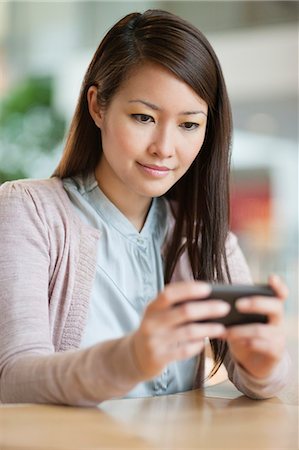 simsearch:6108-06166865,k - Businesswoman text messaging on a mobile phone in an office Stock Photo - Premium Royalty-Free, Code: 6108-06166862