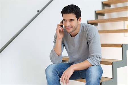 L'homme assis sur les escaliers et parler sur un téléphone mobile Photographie de stock - Premium Libres de Droits, Code: 6108-06166873