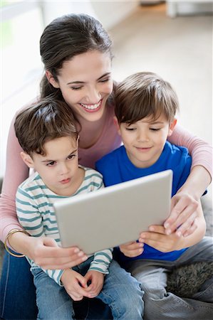 Woman showing a digital tablet to their children Stock Photo - Premium Royalty-Free, Code: 6108-06166992