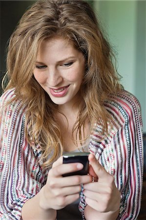 sending - Close-up of a beautiful woman text messaging on a mobile phone Foto de stock - Sin royalties Premium, Código: 6108-06166913