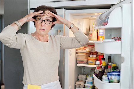 dolor de cabeza - Portrait of an elderly woman looking shocked in front of a refrigerator Foto de stock - Sin royalties Premium, Código: 6108-06167075