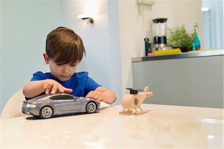 Boy playing with a toy car Foto de stock - Sin royalties Premium, Código: 6108-06167003
