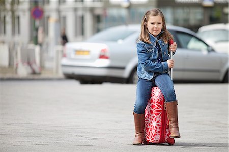 Girl sitting on her luggage Stock Photo - Premium Royalty-Free, Code: 6108-06167017