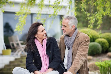 simsearch:6108-06167383,k - Romantic couple sitting in a garden and smiling Stock Photo - Premium Royalty-Free, Code: 6108-06167148