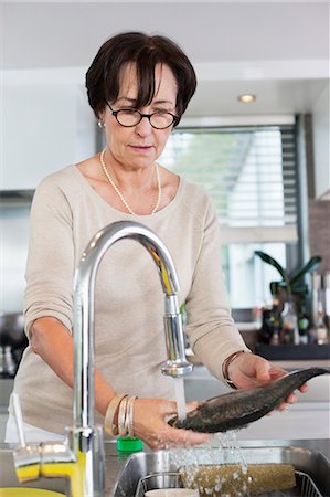 simsearch:6108-05869331,k - Elderly woman washing a fish in a kitchen sink Stock Photo - Premium Royalty-Free, Code: 6108-06167116