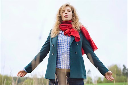 daydreaming (eyes closed) - Beautiful woman daydreaming in a field Stock Photo - Premium Royalty-Free, Code: 6108-06167361