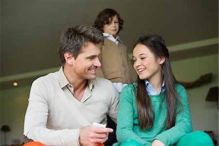 simsearch:6108-06167492,k - Man sitting with his daughter at home Stock Photo - Premium Royalty-Free, Code: 6108-06167492