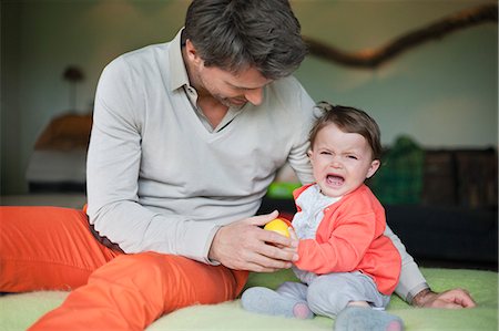 Man consoling his crying daughter Stock Photo - Premium Royalty-Free, Code: 6108-06167494