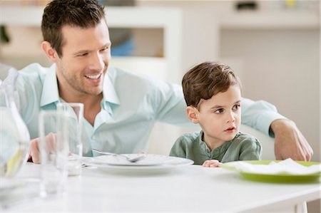 family dining room table - Man with his son sitting at a dining table Stock Photo - Premium Royalty-Free, Code: 6108-06167436