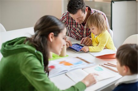 father son study - Couple teaching their children at home Stock Photo - Premium Royalty-Free, Code: 6108-06167547