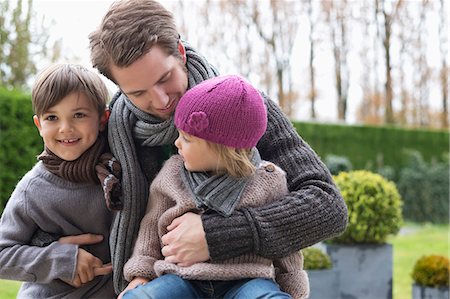 father hugging his son and daughter - Man hugging his two children Stock Photo - Premium Royalty-Free, Code: 6108-06167551