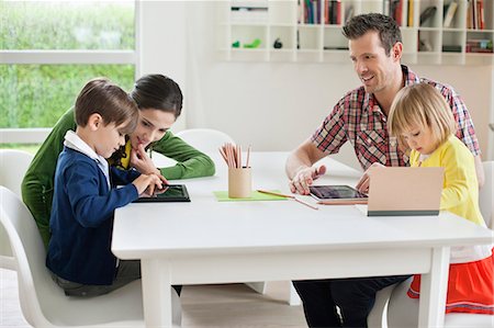 father son study - Couple teaching their children at home Stock Photo - Premium Royalty-Free, Code: 6108-06167586