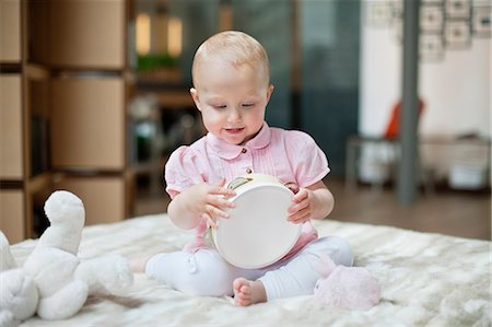 Baby girl playing with a tambourine Stock Photo - Premium Royalty-Free, Code: 6108-06167661
