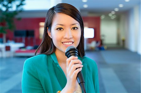 simsearch:6108-06167827,k - Portrait of a businesswoman holding microphone in an office Stock Photo - Premium Royalty-Free, Code: 6108-06167862