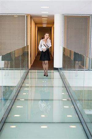 simsearch:6108-06167827,k - Businesswoman talking on a mobile phone in an office corridor Stock Photo - Premium Royalty-Free, Code: 6108-06168086