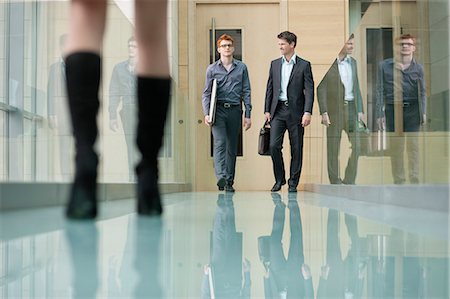 Business executives walking in a corridor Stock Photo - Premium Royalty-Free, Code: 6108-06168023