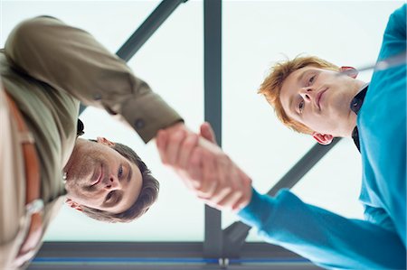 Businessmen shaking hands in an office Stock Photo - Premium Royalty-Free, Code: 6108-06168162