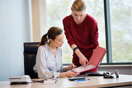 datrice di lavoro - Businesswoman signing documents with her secretary Fotografie stock - Premium Royalty-Free, Codice: 6108-06168169