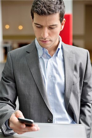 Close-up of a businessman text messaging Stock Photo - Premium Royalty-Free, Code: 6108-06168317
