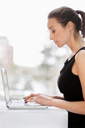 simsearch:6108-06167827,k - Businesswoman working on a laptop in an office Stock Photo - Premium Royalty-Free, Code: 6108-06168470
