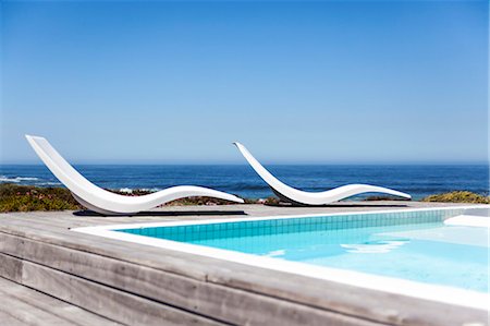 swimming pool nobody - Modern reclining chairs at the poolside Photographie de stock - Premium Libres de Droits, Code: 6108-06904408