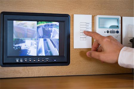 flatscreen - Person's hand pushing buttons for a security surveillance system at home Stock Photo - Premium Royalty-Free, Code: 6108-06904552