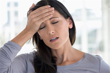 Close-up of a woman suffering from a headache Foto de stock - Sin royalties Premium, Código: 6108-06904777