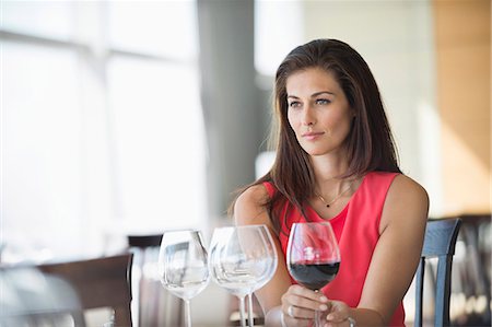 Woman holding a wine glass and thinking in a restaurant Stock Photo - Premium Royalty-Free, Code: 6108-06904788