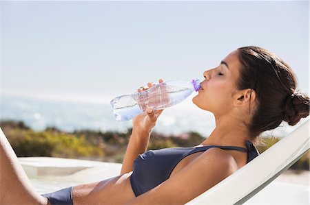 simsearch:6108-06907213,k - Beautiful woman drinking water on the beach Stock Photo - Premium Royalty-Free, Code: 6108-06904720