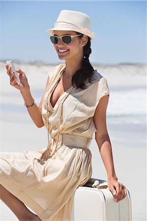 simsearch:6108-06907213,k - Beautiful woman text messaging on a cell phone on the beach Stock Photo - Premium Royalty-Free, Code: 6108-06904865